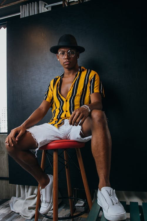 A model posing in a striped shirt and white shorts