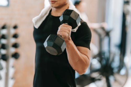 A person holding a dumbbell in a gym
